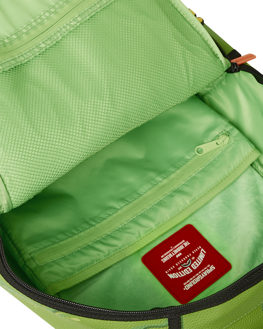 Side angle of the clear Sprayground backpack with functional zipper pockets.