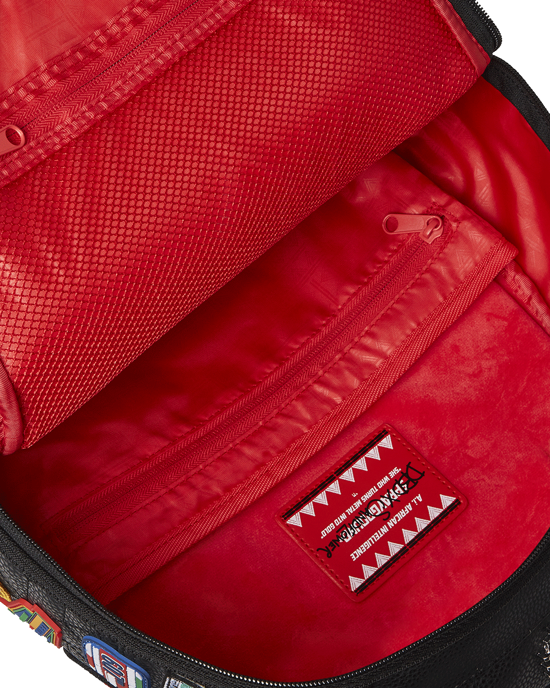 Detail shot of gold zippers and Sprayground Authentic badge on the faux leather backpack.