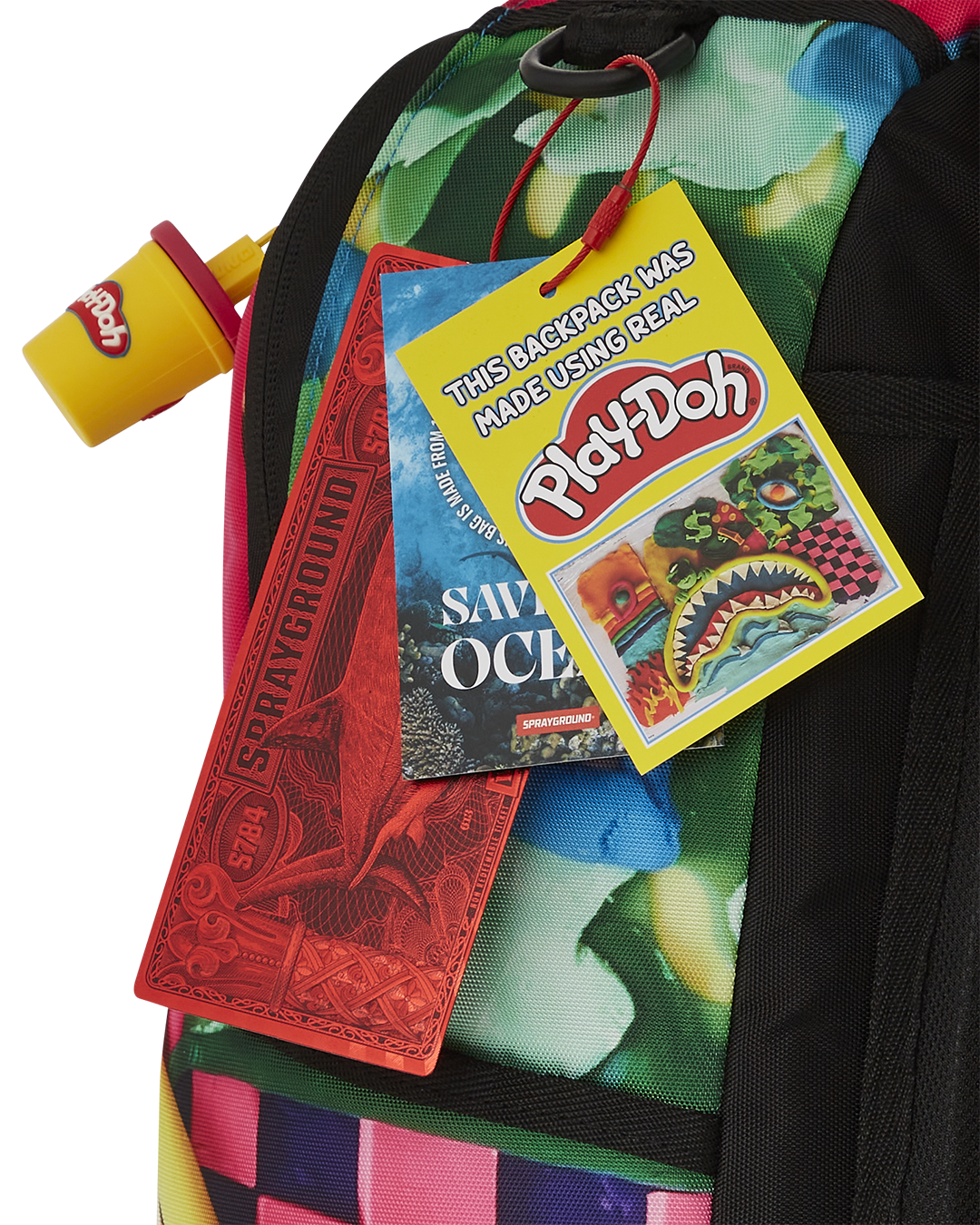 Close-up of pink Sprayground backpack’s front pocket and metal hardware