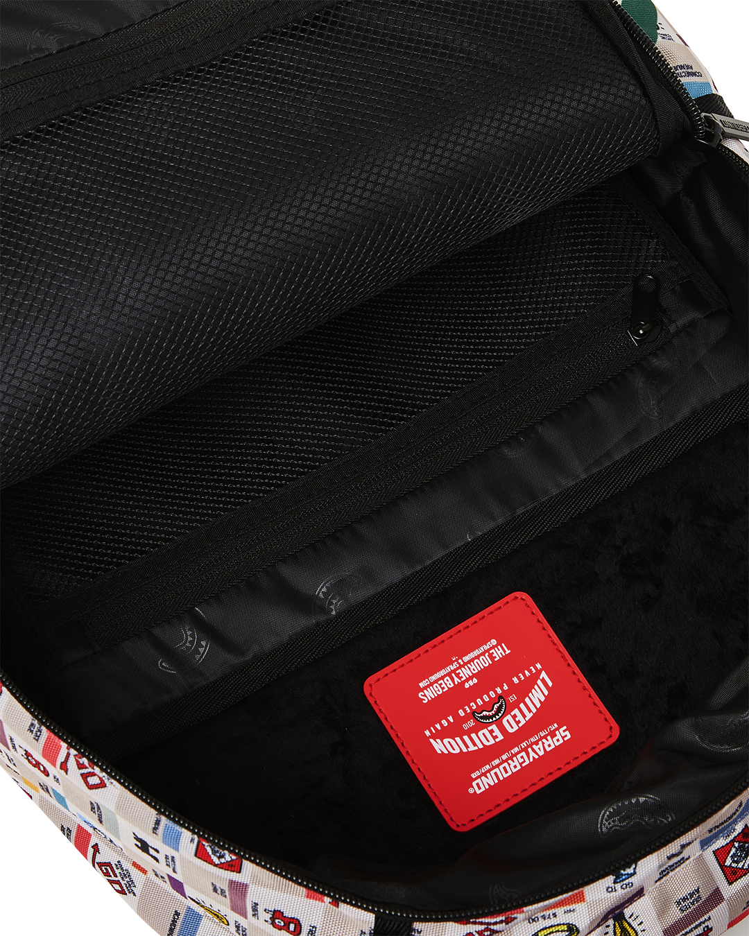 Sprayground backpack pink version on a park bench with laptop visible in compartment