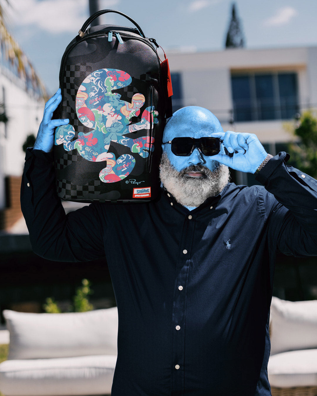 Front view of the Smurfs faux leather backpack with gold zippers and playful design
