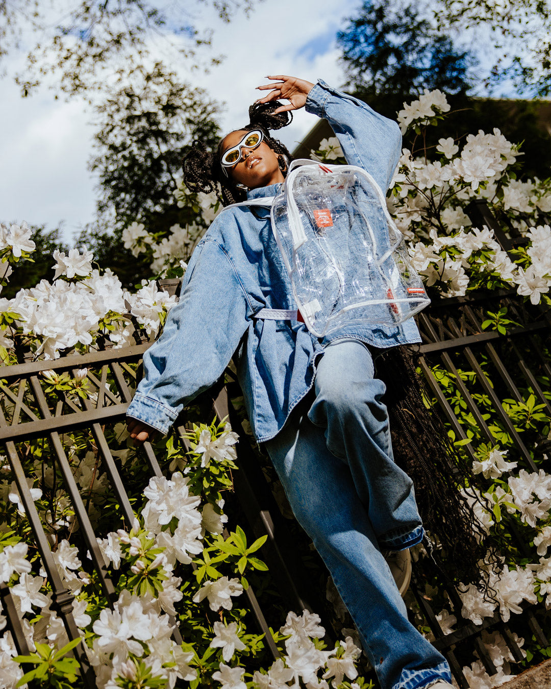 Clear Vision backpack worn by student walking through urban park
