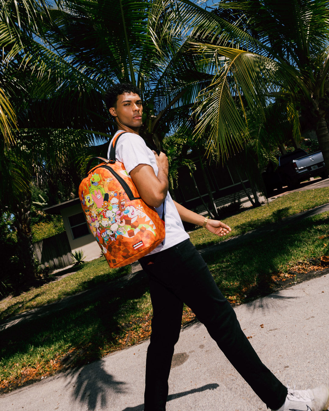 Front angle of the DLXV faux leather backpack showing zipper pocket and metal hardware