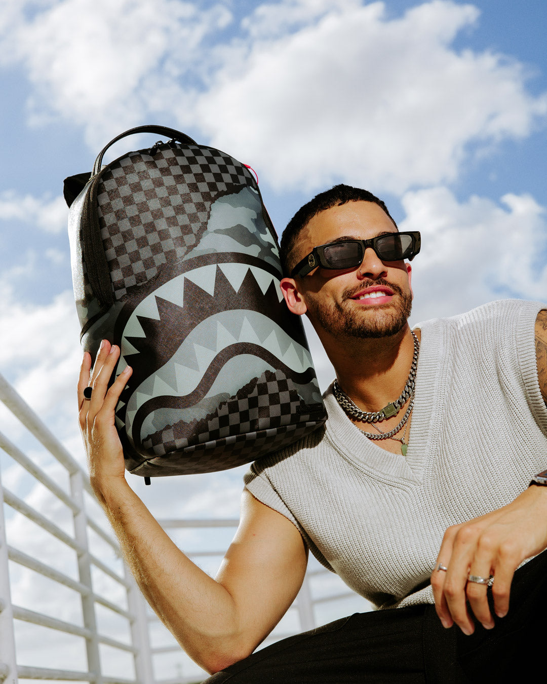 Model wearing Sprayground backpack pink version on city street during weekend getaway