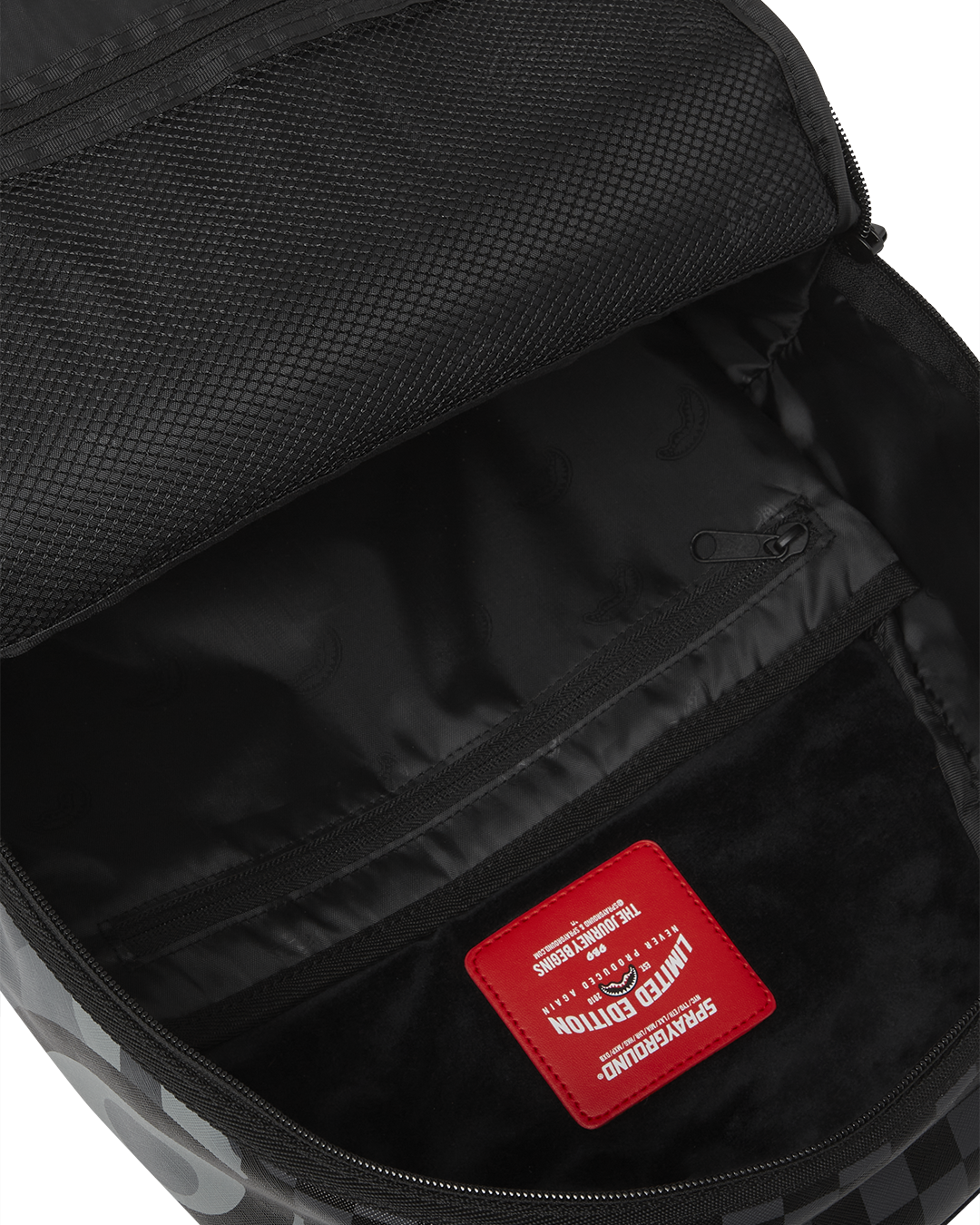 Open Sprayground backpack revealing velour compartments and mesh organization