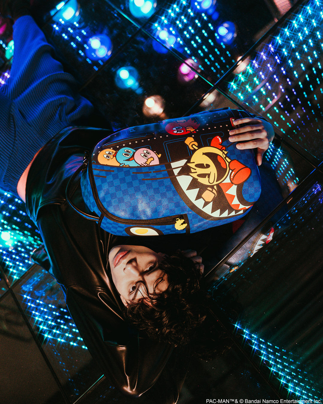 Close-up of PAC-MAN Livin the Dream faux leather backpack showing gold zippers and metal hardware