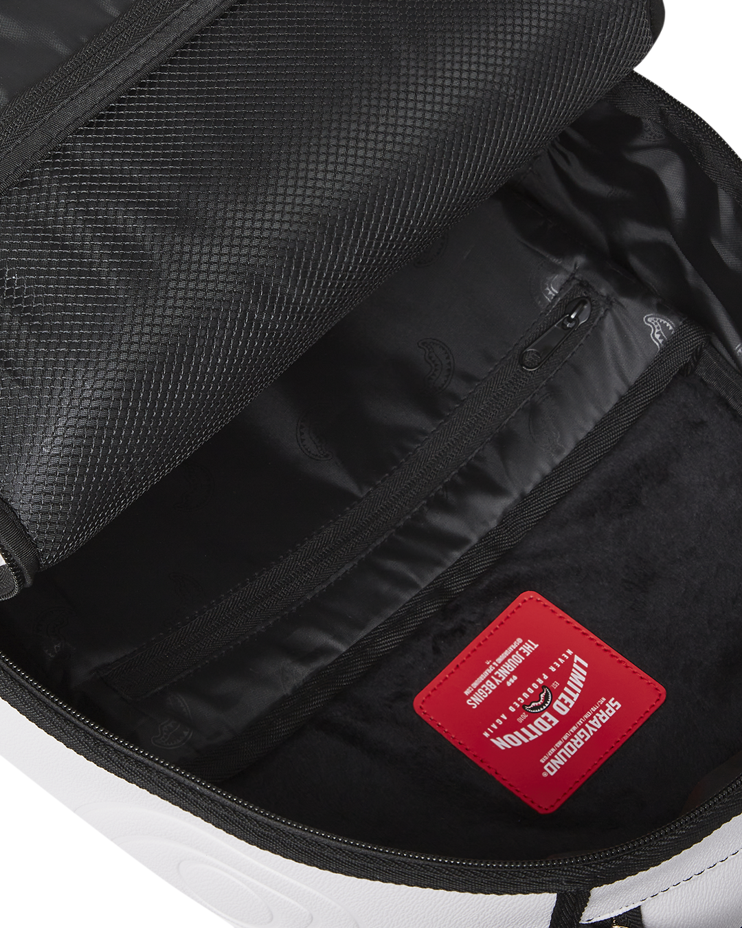 Interior view of the backpack, highlighting the velour laptop compartment and mesh organizer.