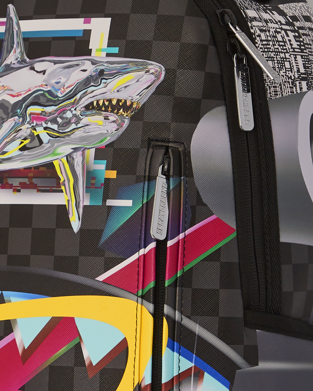 Close-up of Sprayground shark backpack’s gold zippers and textured faux leather