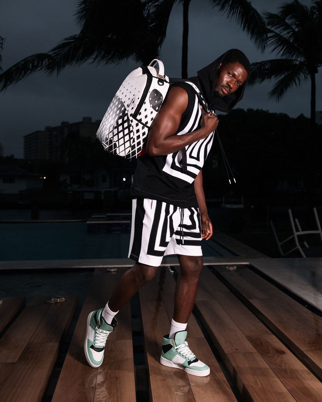 DLXV faux leather backpack worn casually over one shoulder in urban setting