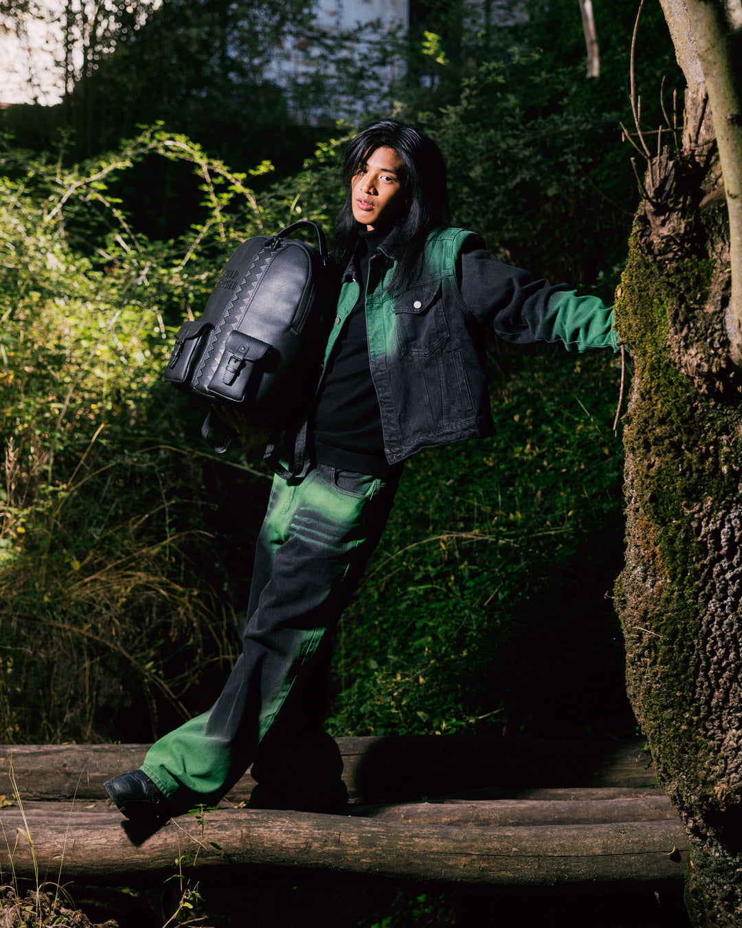Front view of the travel backpack showing cargo pockets and sleek faux leather finish