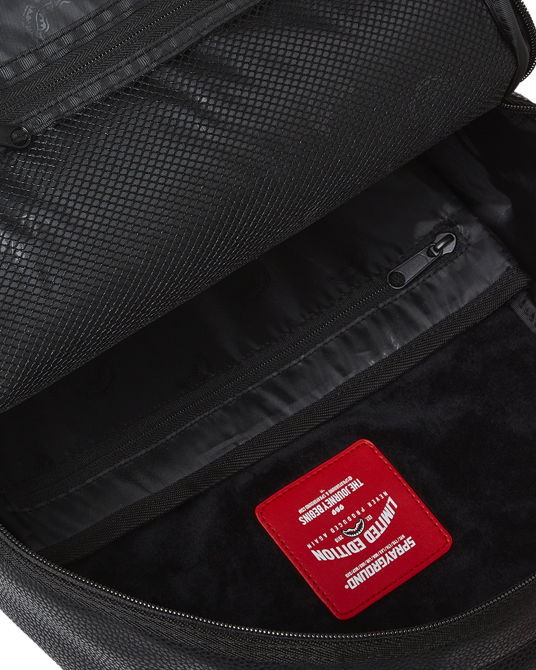 Back view showing mesh padding and slide-through sleeve for carry-on luggage