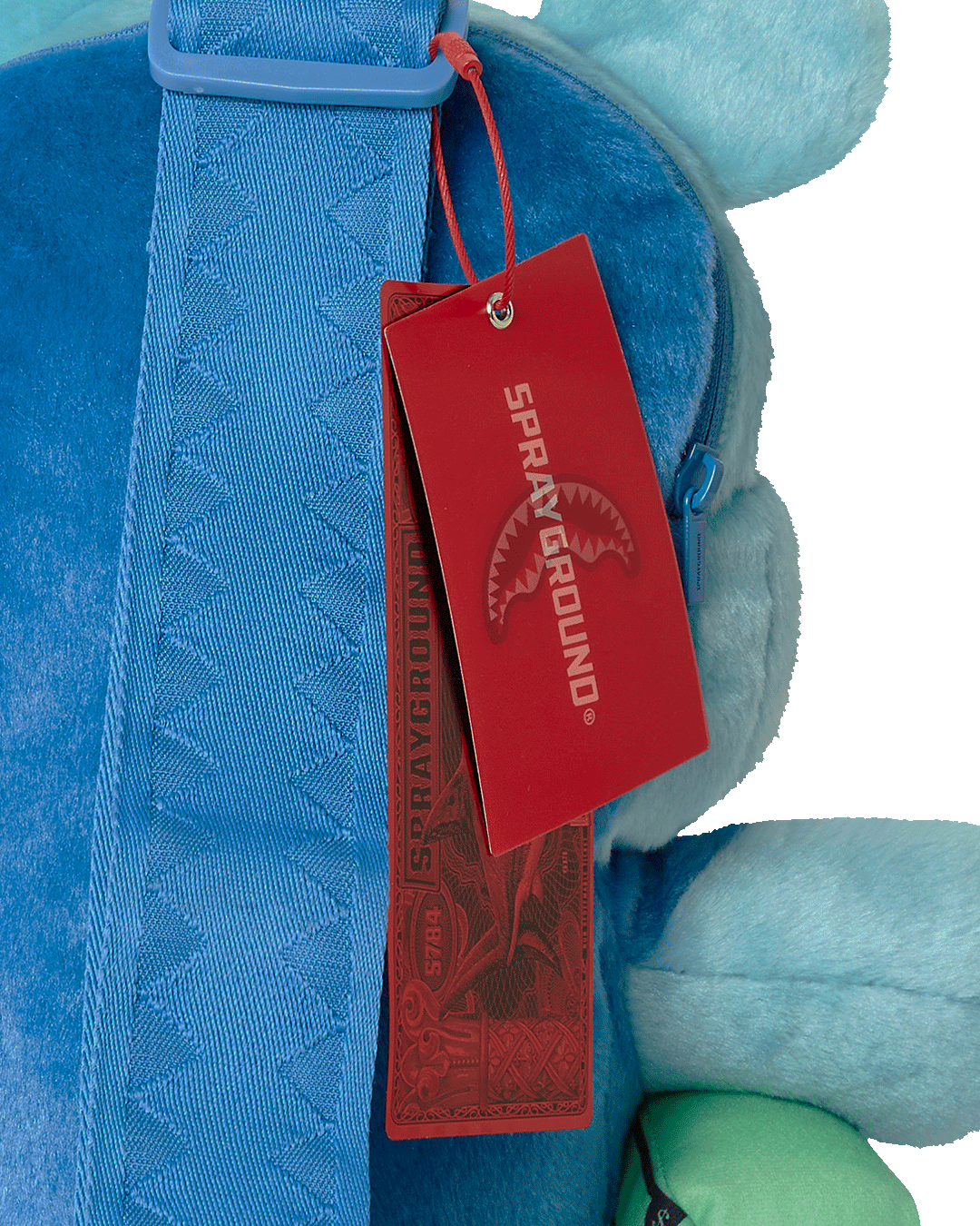 Close-up of embroidered ears and iridescent goggles on crossbody bag front pocket