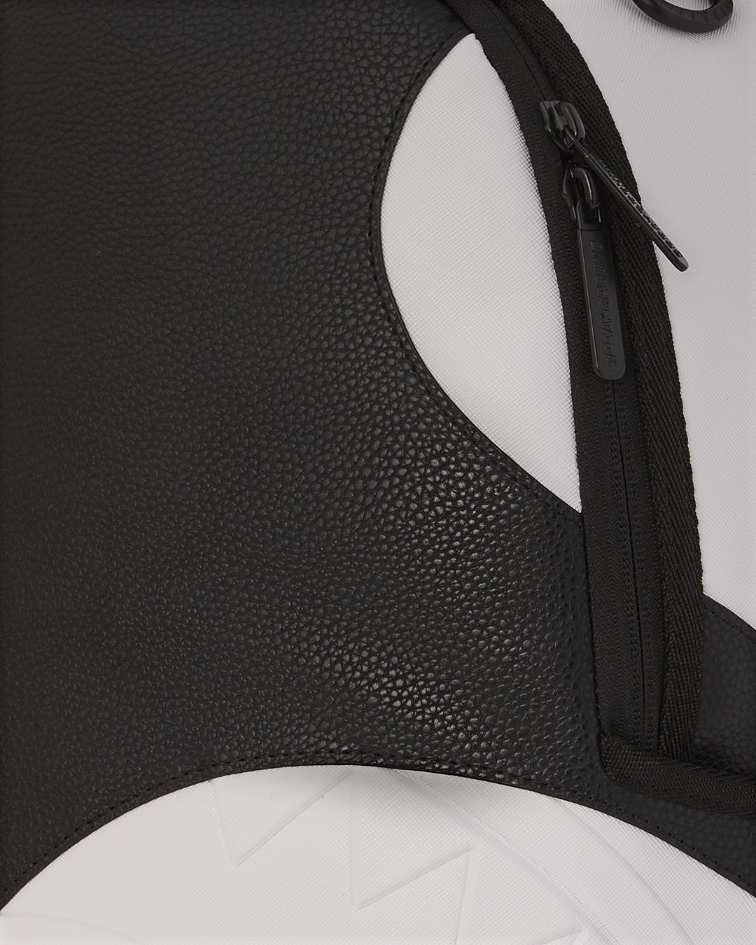 Front view of faux leather backpack showing gold zippers and badge