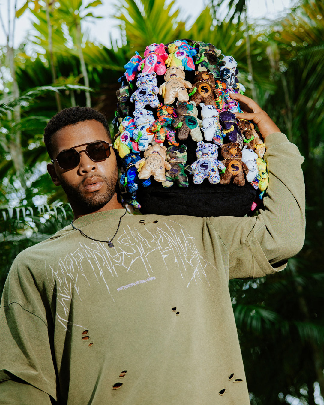Front view of the designer backpack with plush teddy bears and gold zippers