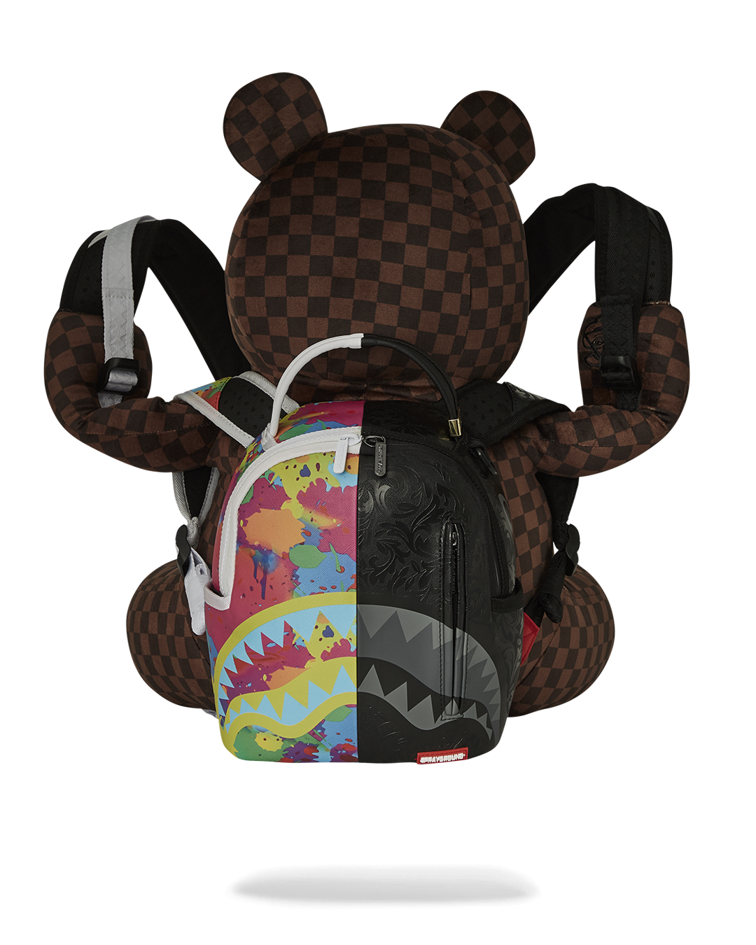 Teddy bear backpack lying on a forest floor, showcasing its durable design