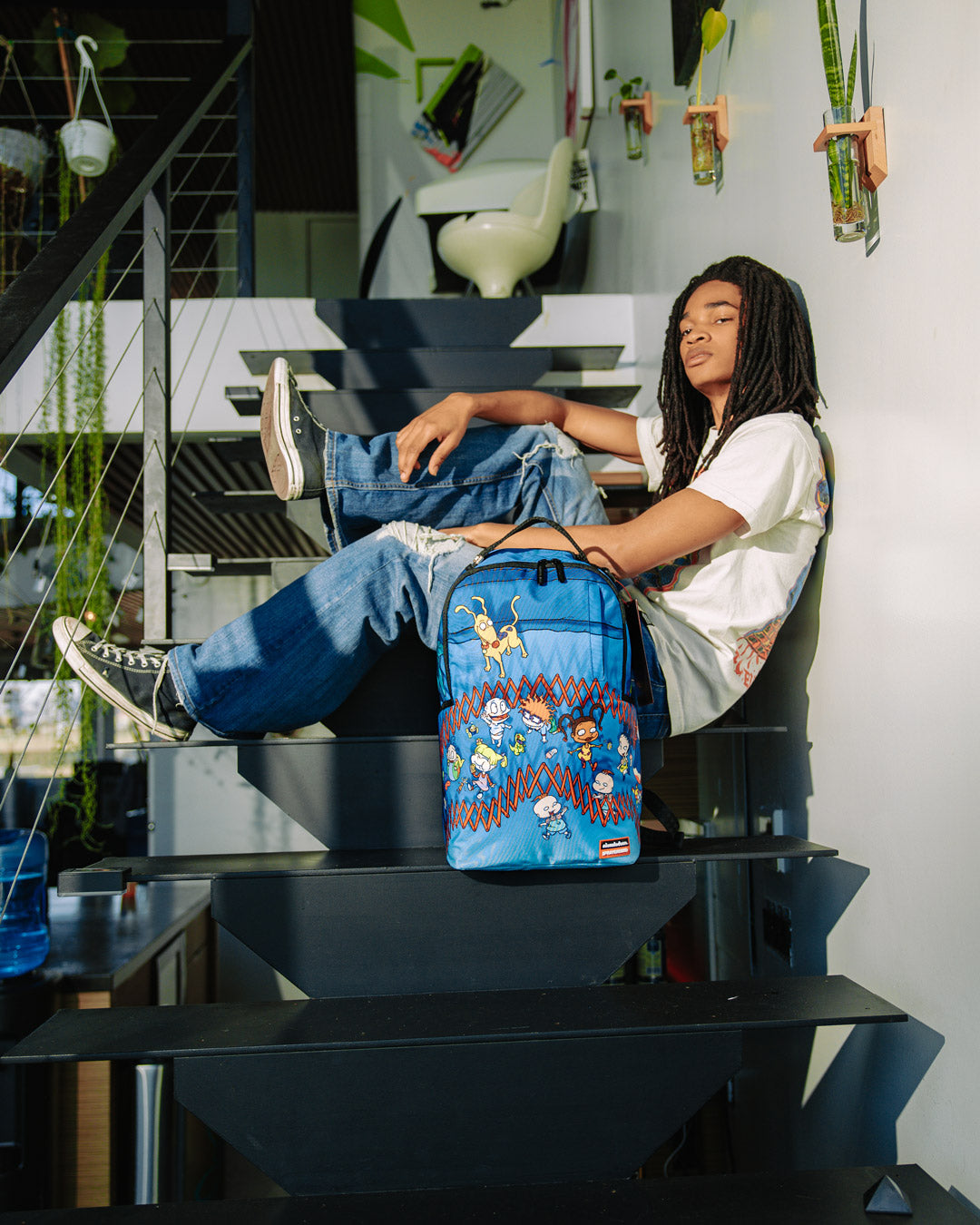Side view of the RUGRATS backpack with pockets and gold zippers.