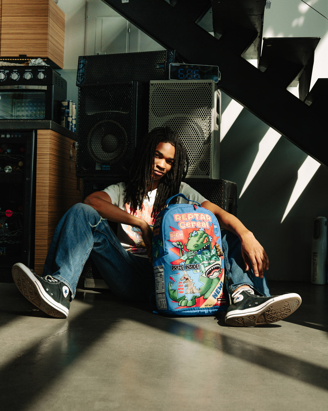 Side angle highlighting adjustable straps and gold zippers on Sprayground backpack