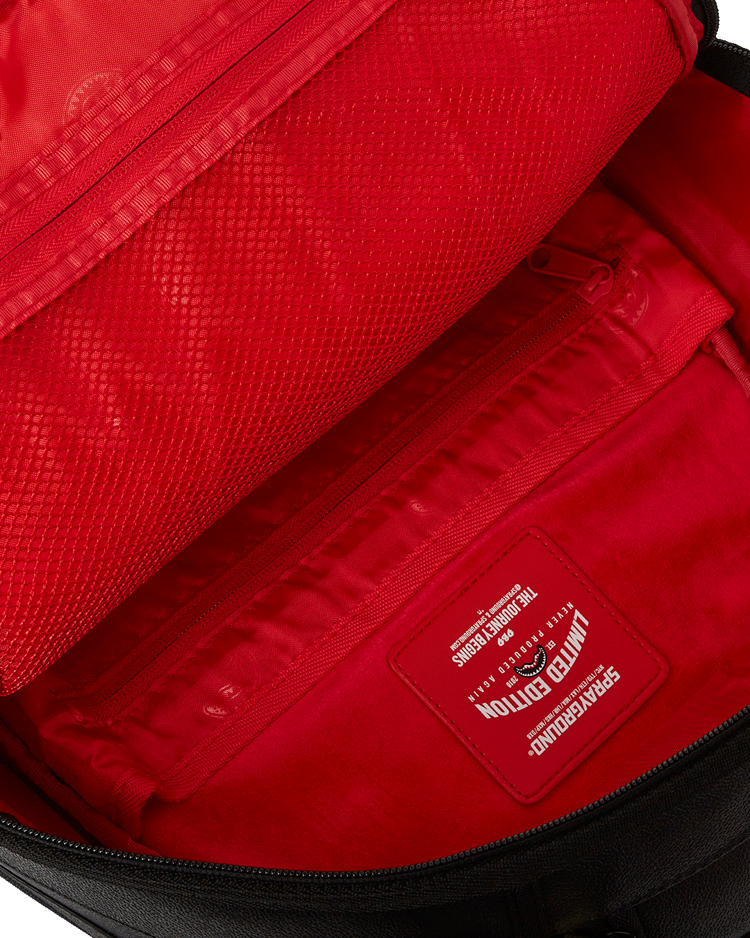 Front view of the faux leather backpack with cargo pocket and red chain embellishments
