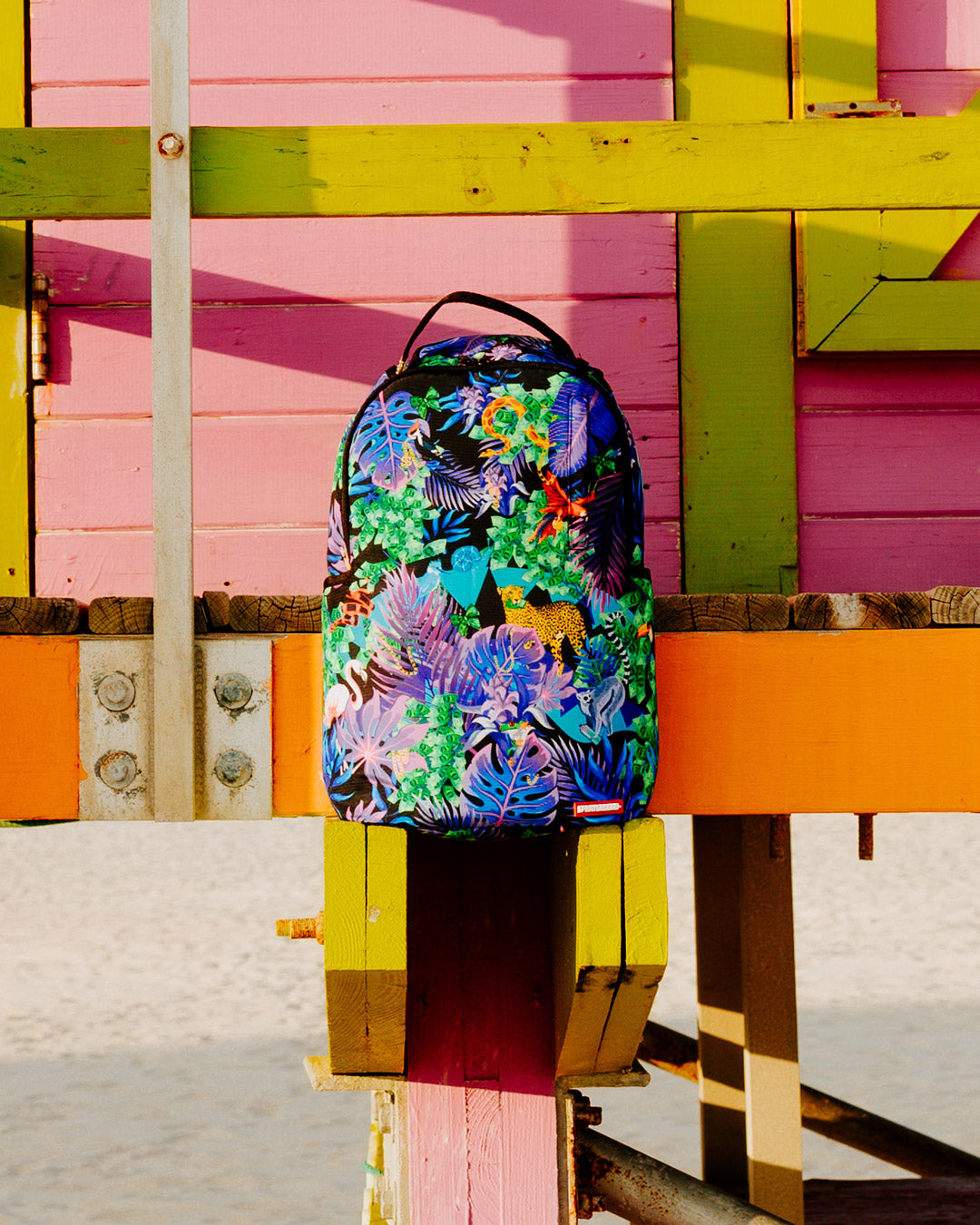 Tropical Night Deluxe Laptop Backpack attached to carry-on luggage.