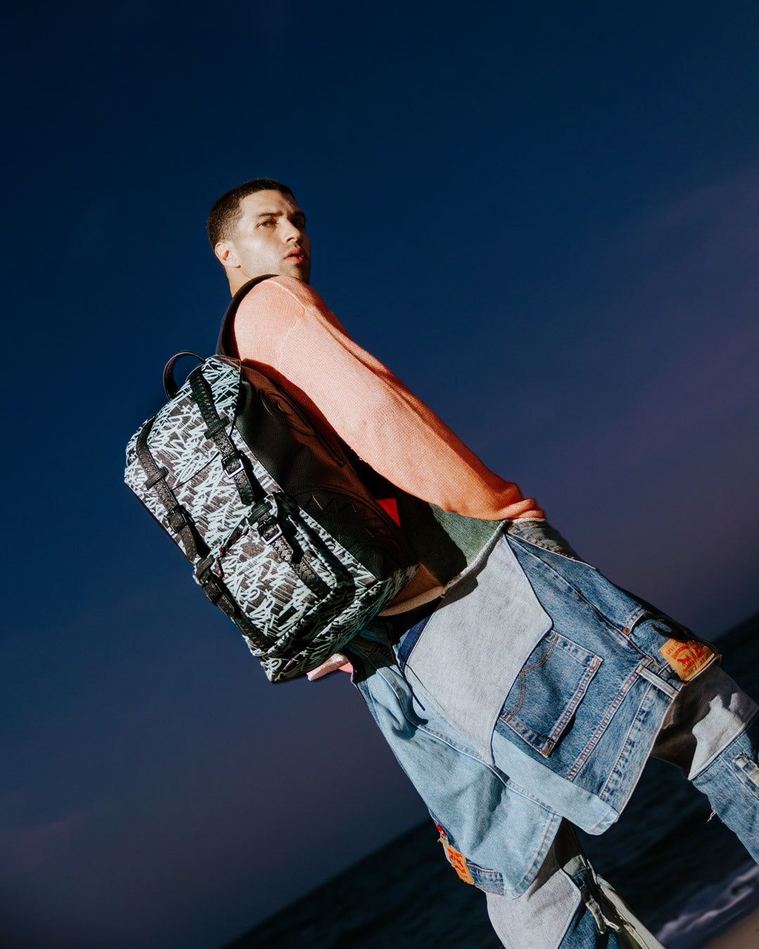 Close-up of the backpack’s magnetic snap buckle and embossed sharktooth straps