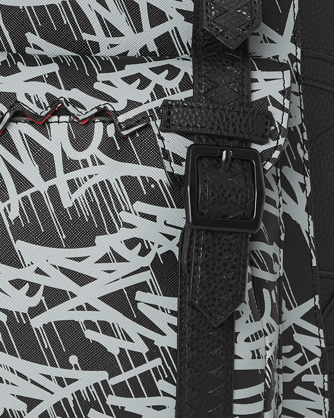 Close-up of the backpack’s magnetic snap buckle and embossed sharktooth straps
