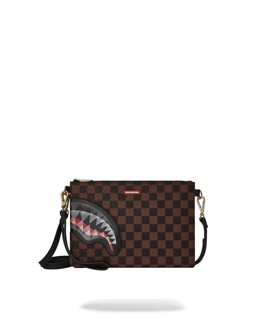 Gold clutch purse with shark mouth design lying flat on marble surface