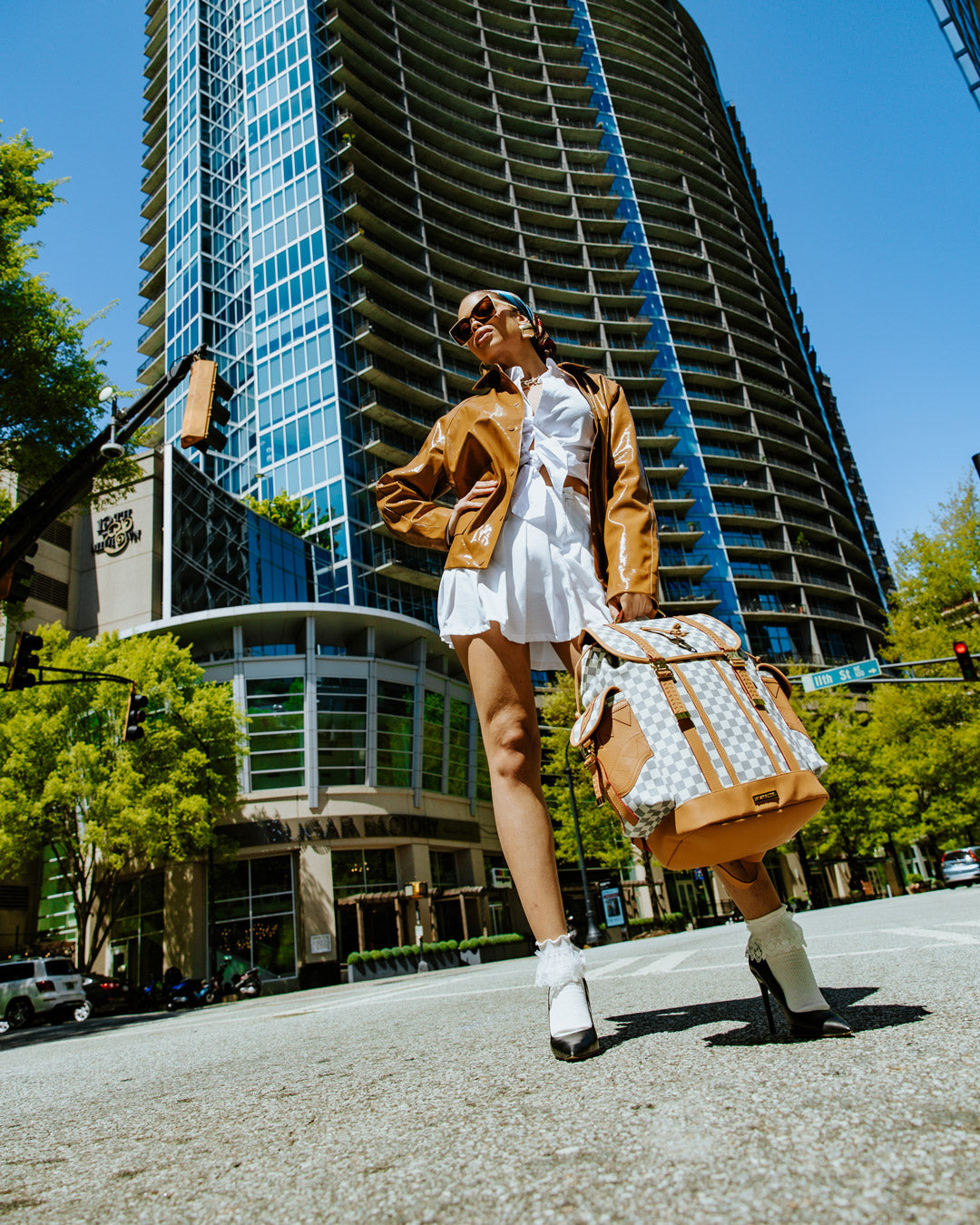 Front view of Henny Latte faux leather backpack showing buckled flap and side pockets