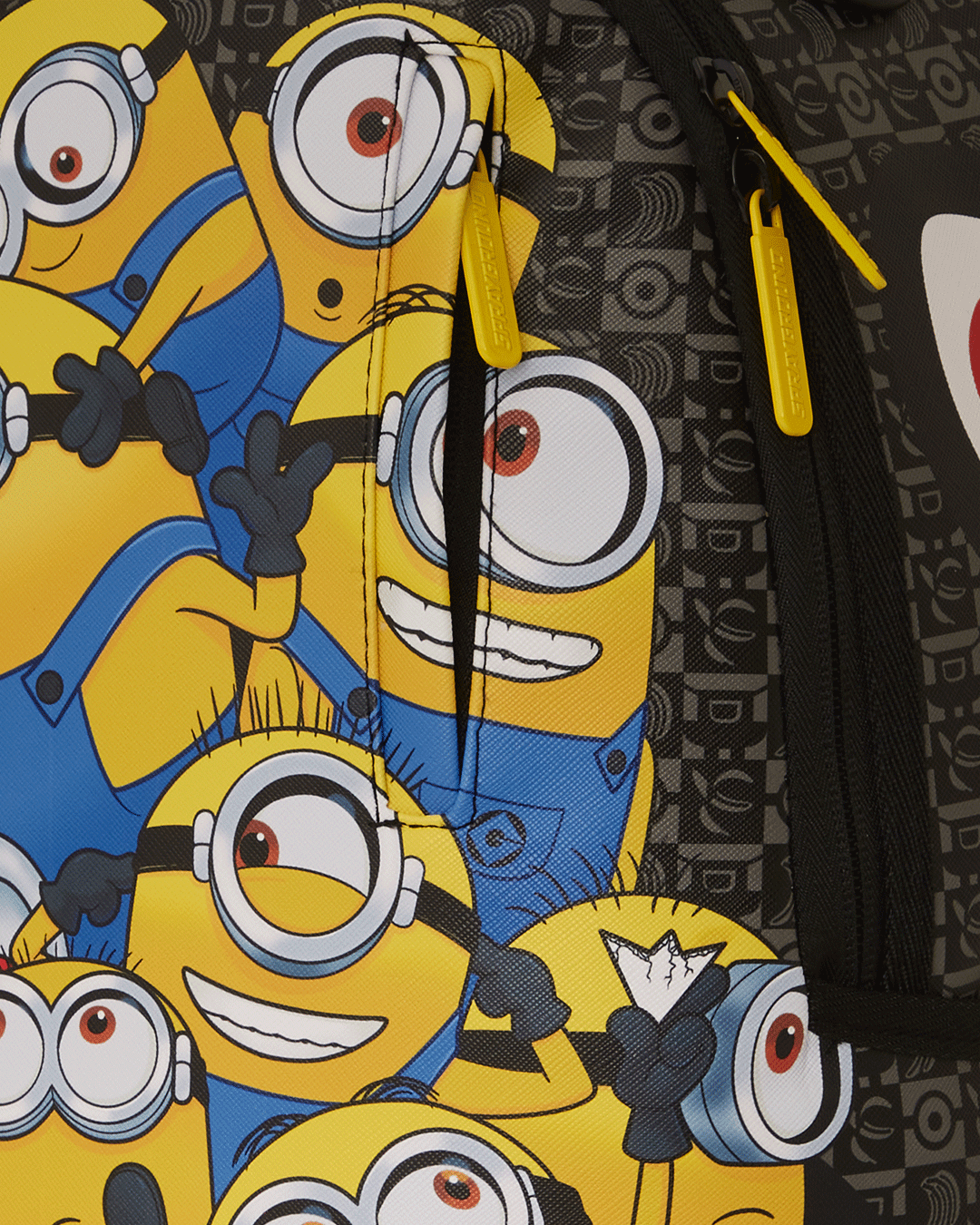 Close-up of Sprayground Minions backpacks faux leather texture and zippers