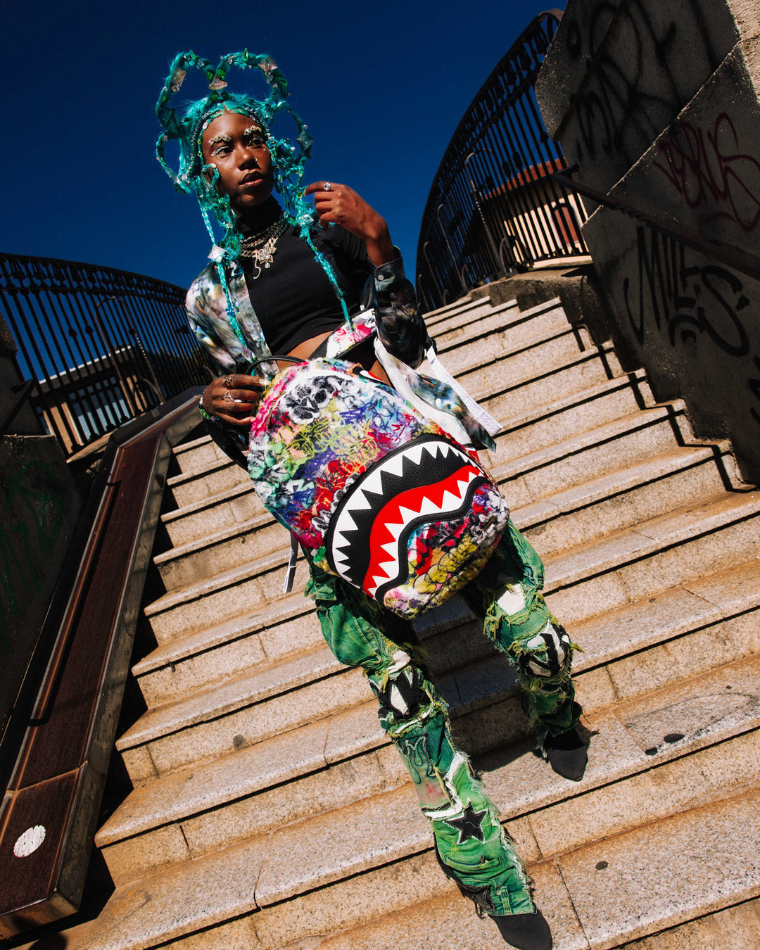 Side pocket of Graffiti Luxe Backpack for quick access to essentials.