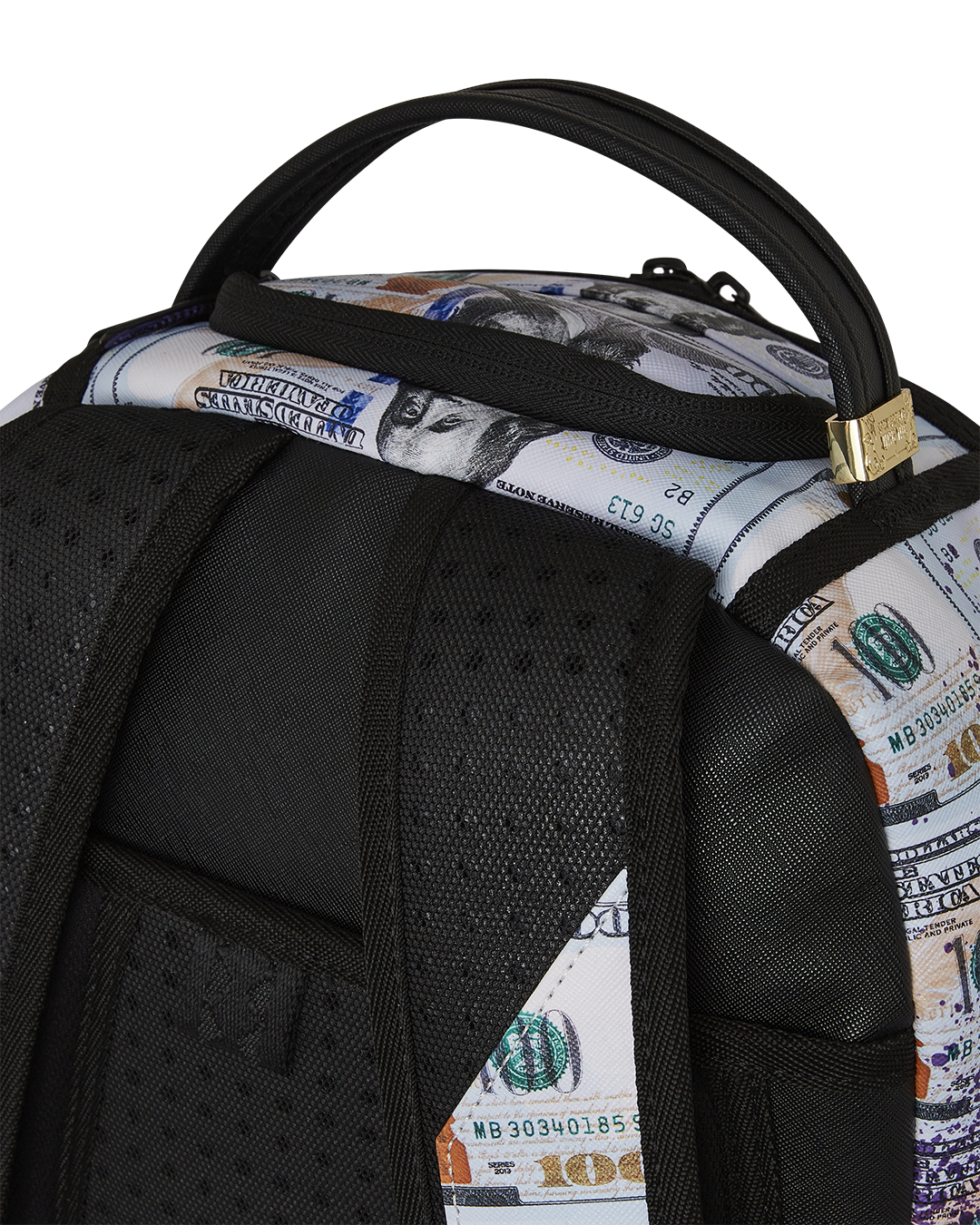 Close-up of the faux leather exterior with gold zippers and metal badge on the backpack