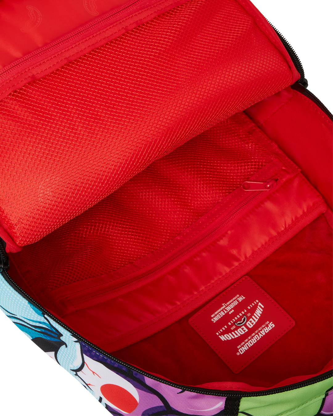 Close-up of the backpacks gold zippers with metal hardware and Sprayground Authentic badge.