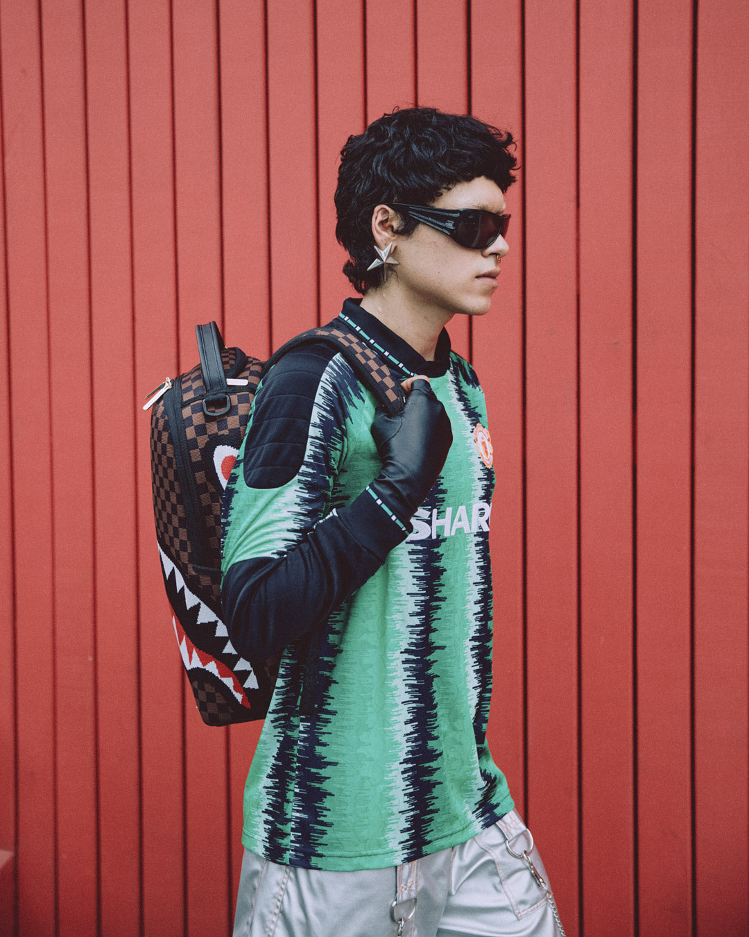 Side angle of the clear Sprayground backpack with ergonomic straps and gold zippers.