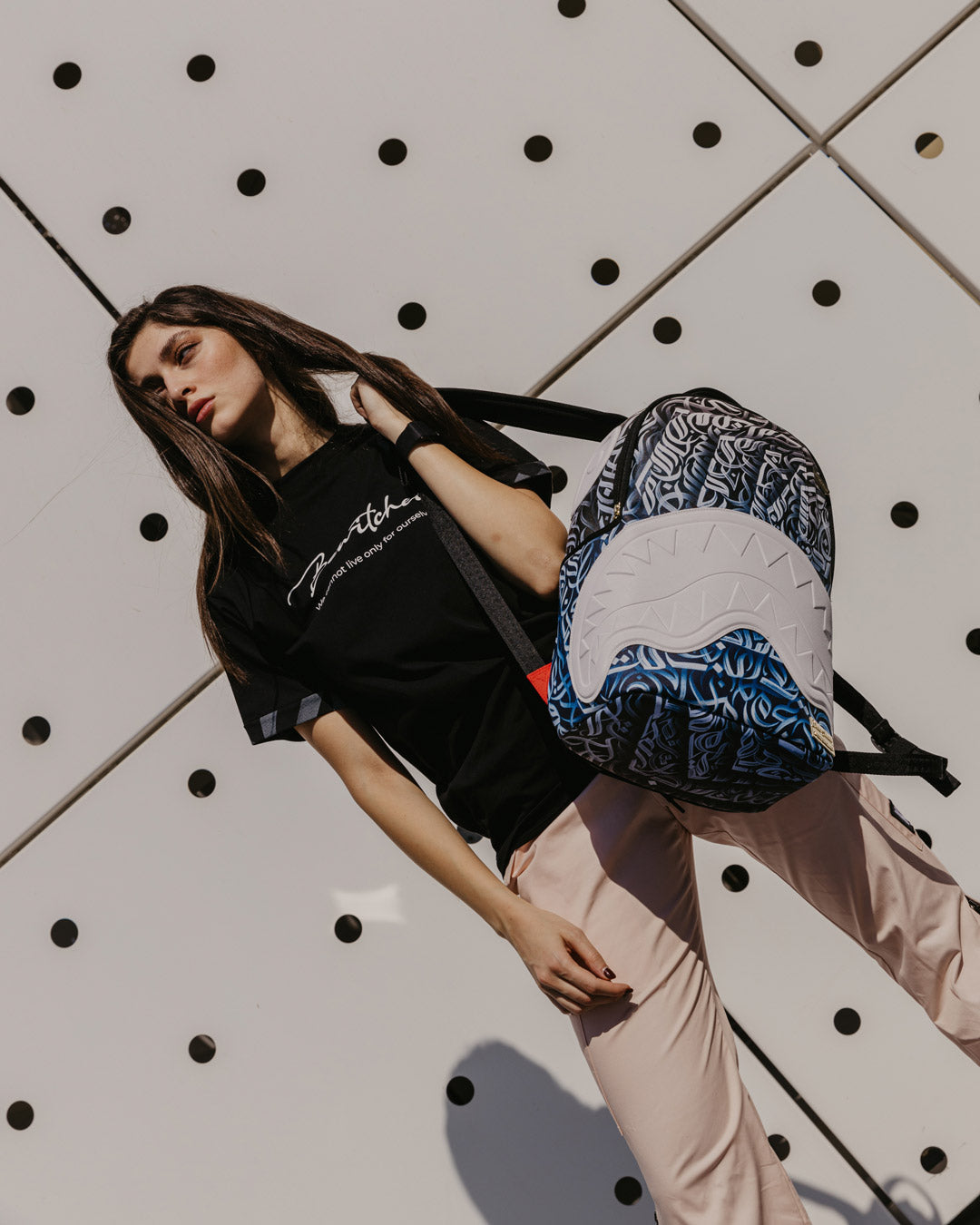 Side profile showing adjustable straps and side pockets of the Sprayground limited edition backpack