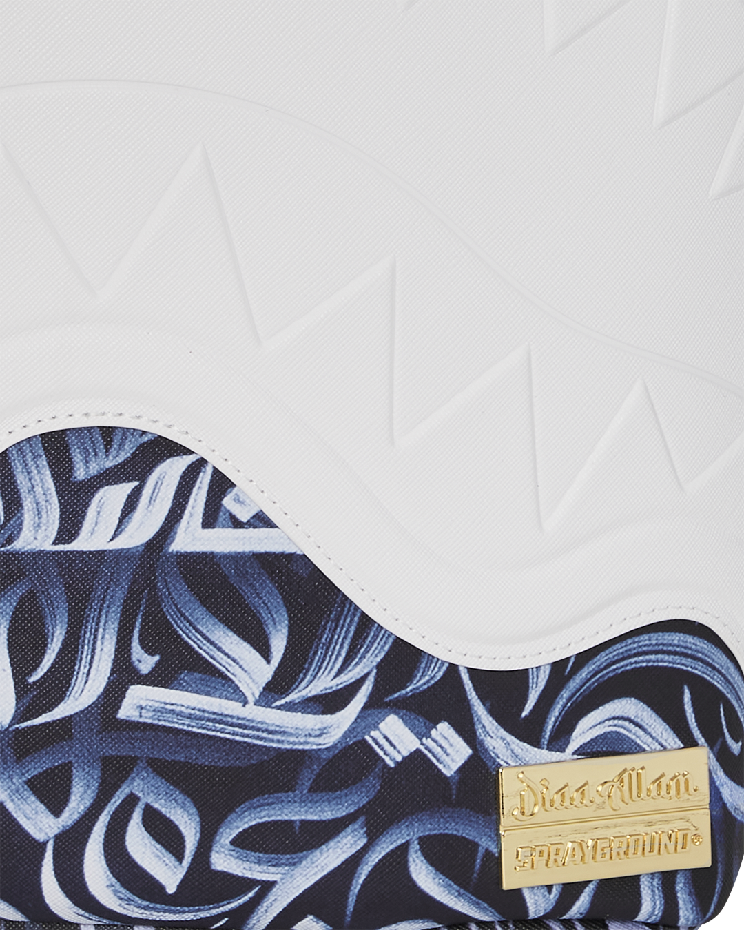 Detail shot of gold zippers and Seeking Perfection Arabic calligraphy artwork