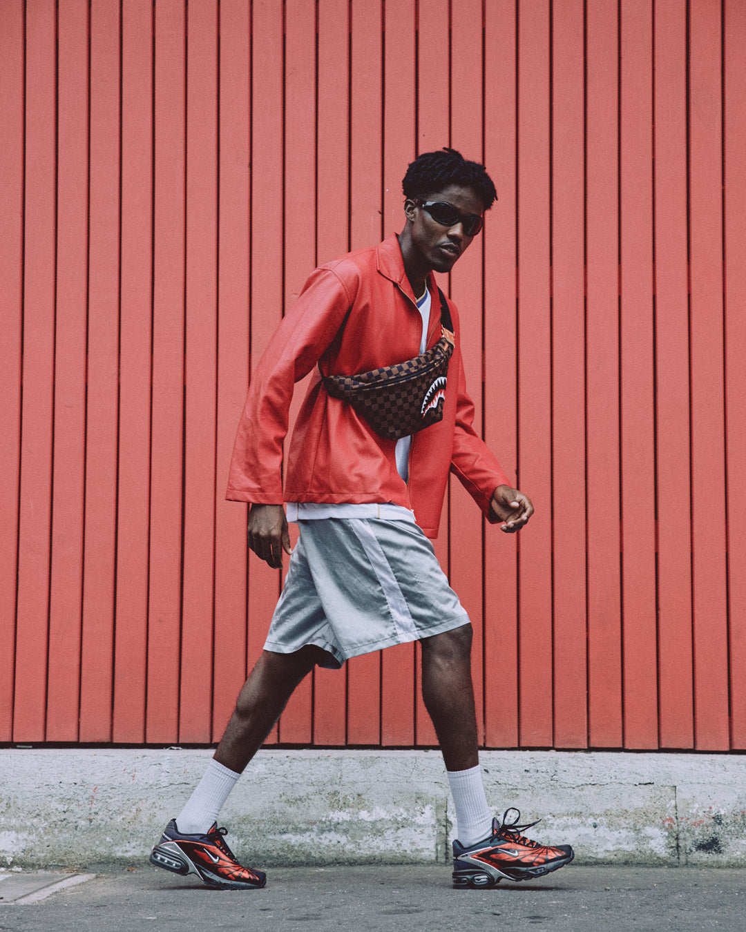 Model wearing the black crossbody bag diagonally with urban backdrop