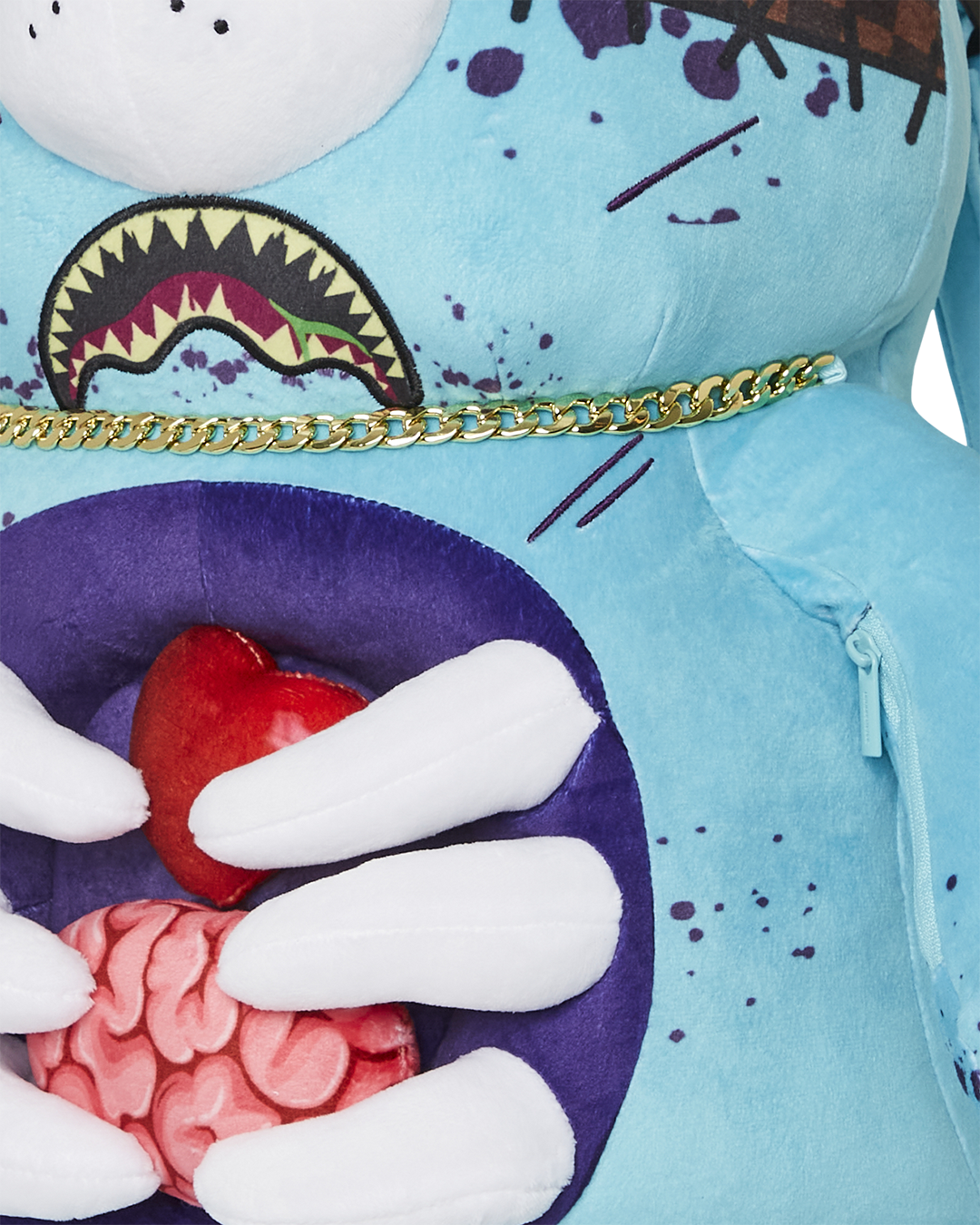 Close-up of Zombie Bear plush backpacks brain unzipping to reveal secret pocket