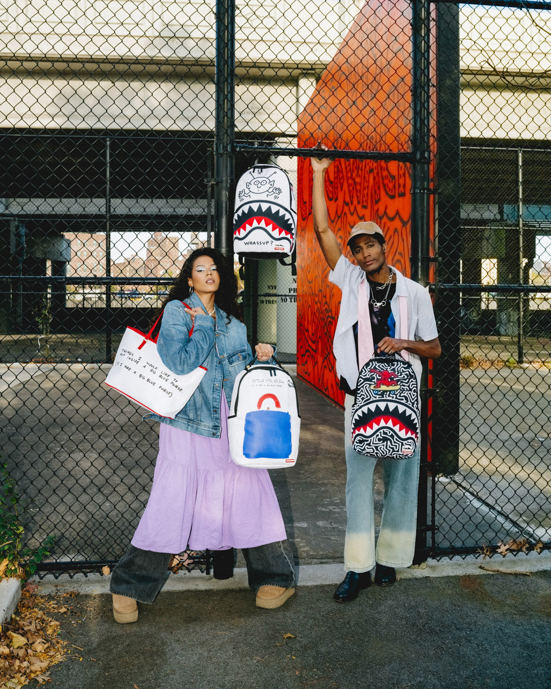 Front-facing view of the pink Sprayground backpack with Keith Haring alien artwork