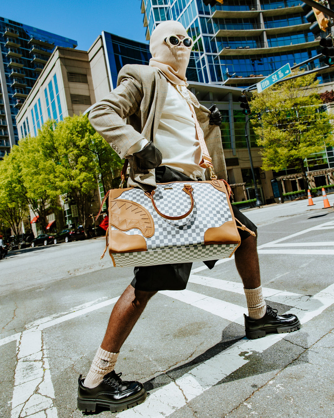 Side view of the Henny Latte Pyramid Duffle showcasing its sleek faux leather finish