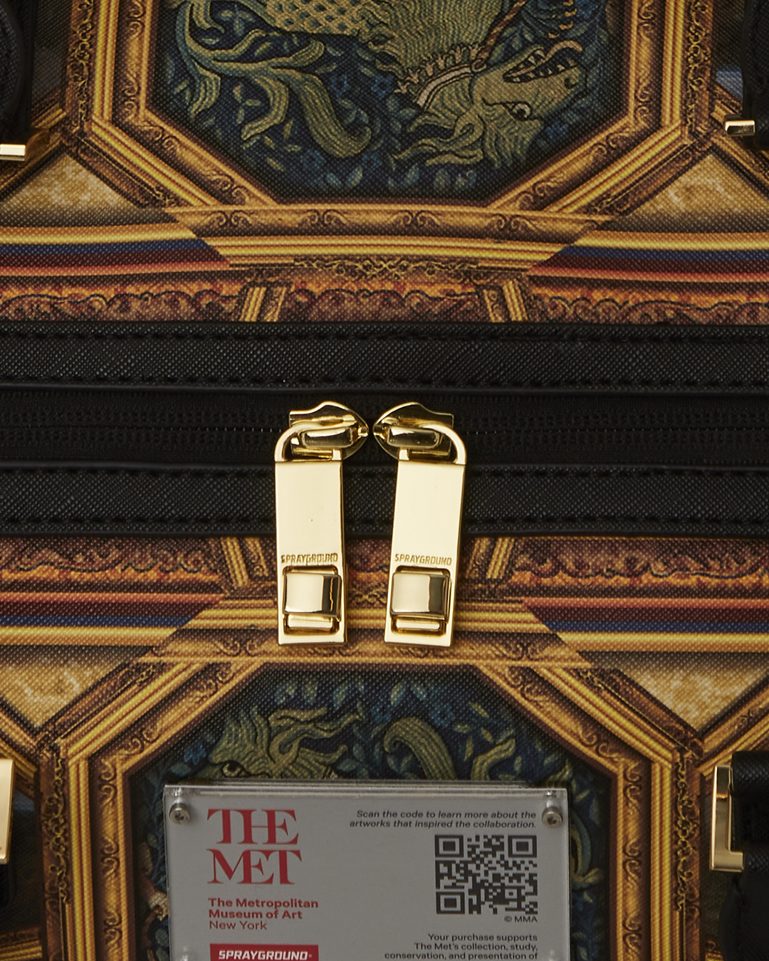 Close-up of the faux leather texture and gold zippers on the duffle bag.