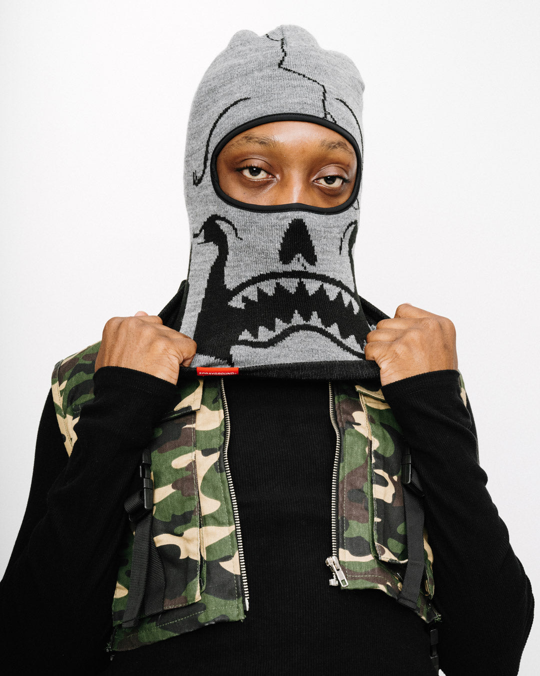 Model wearing black ski mask near Chicago skyline in snowy conditions