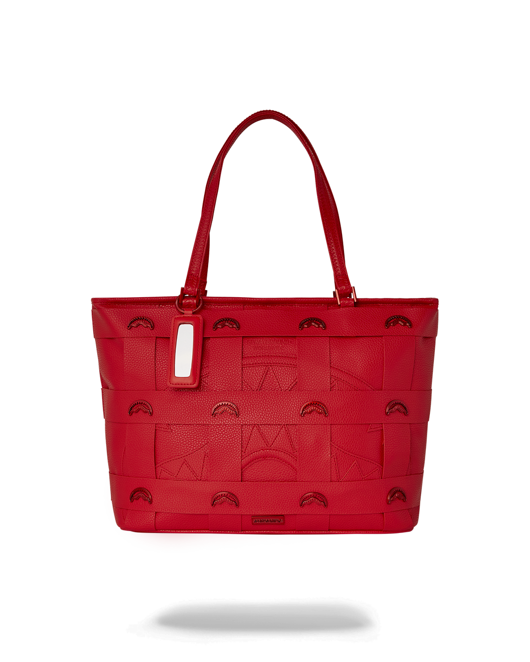 Sprayground leopard print tote bag held by handles against a city backdrop