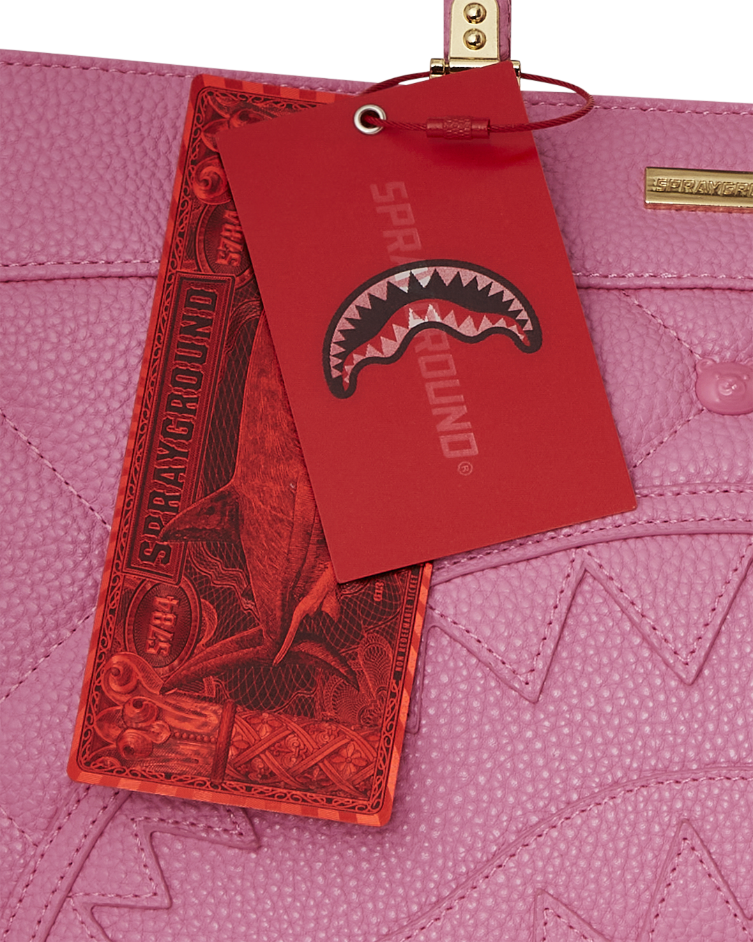 Front view of the pink tote bag with bear face studs and gold accents