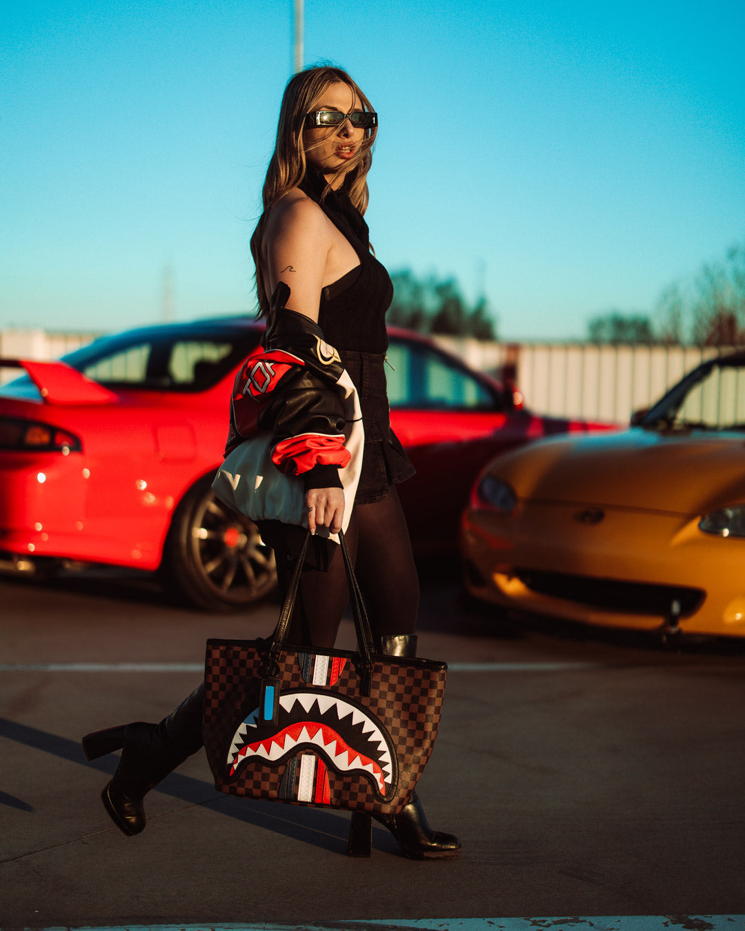 Stylist carrying the large Michael Kors tote bag alongside the Sprayground tote for size comparison