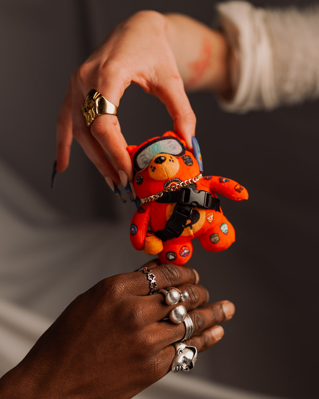 Bear-shaped plush keychain hanging from canvas backpack, suited for urban explorers