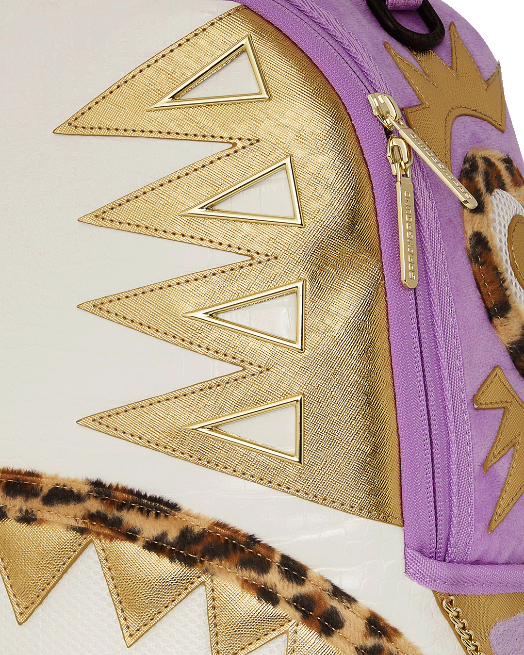 Close-up of Sprayground’s pyramid design and gold zippers