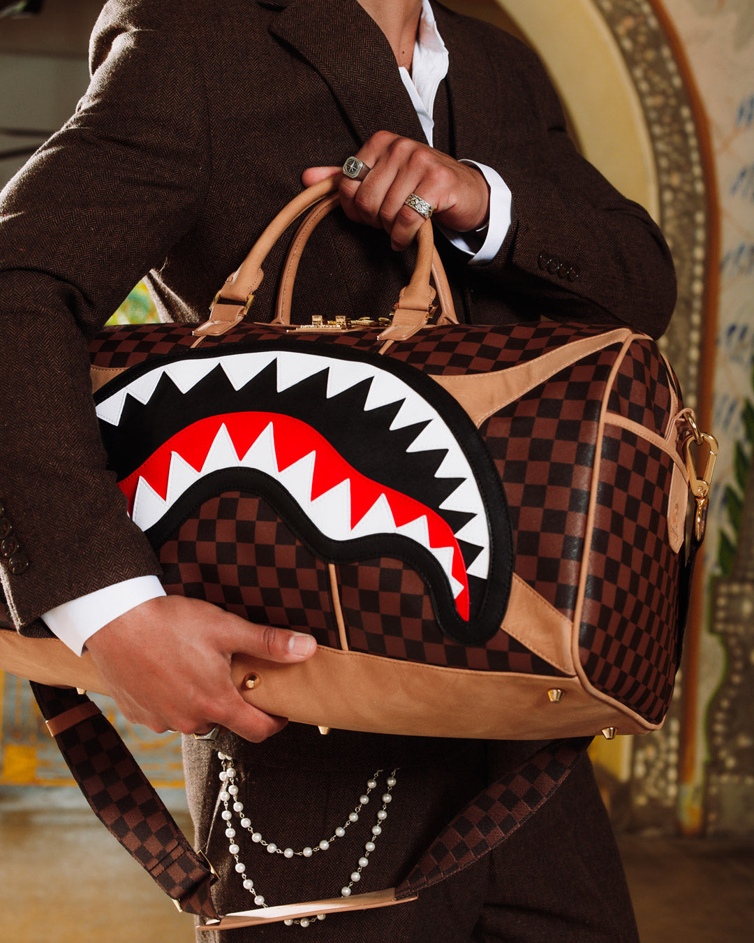 Close-up of Hennyville duffle bags zippered sneaker pocket and gold hardware.