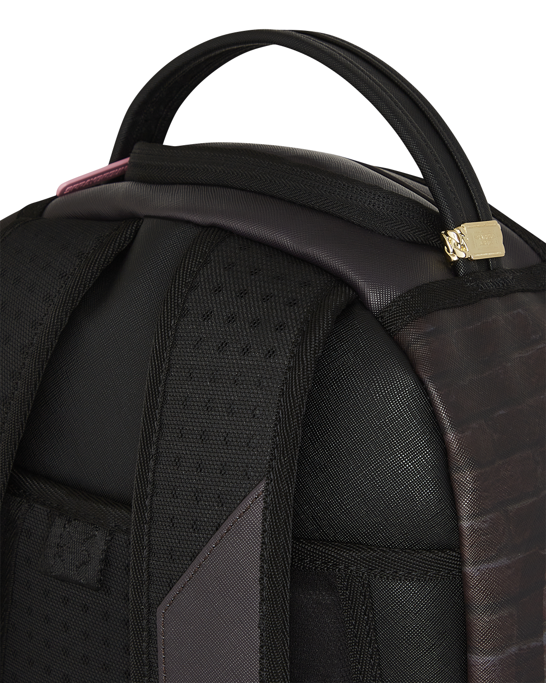 Close-up of gold zippers and metal Sprayground badge on designer backpack