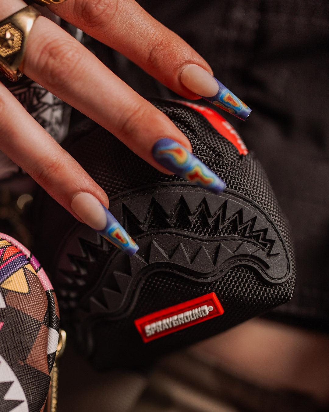 Close-up of the keychains ballistic polyester material and SPRAYGROUND printed zipper tape.