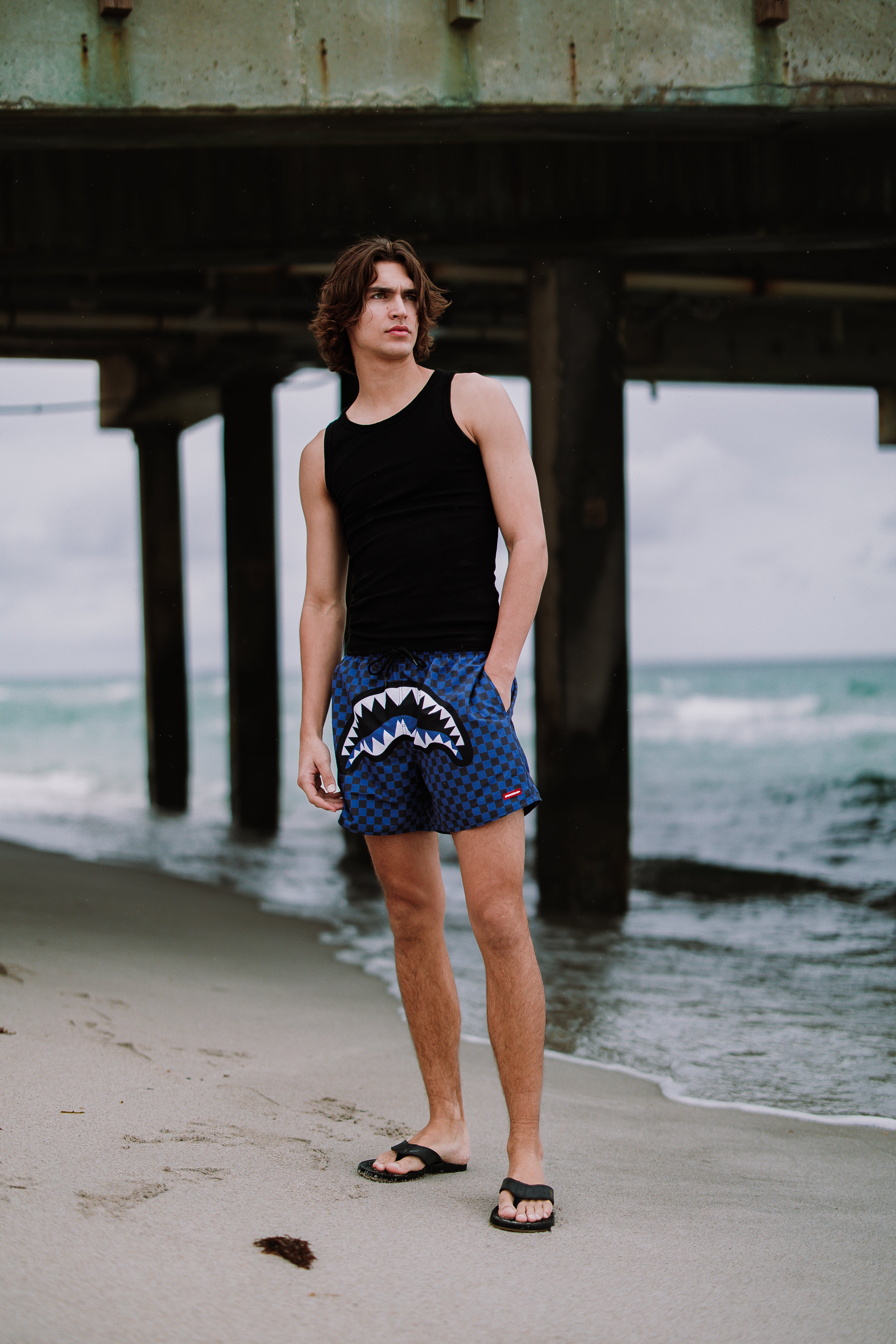 Woman wearing Parisian Nights Swim Shorts, walking along the beach