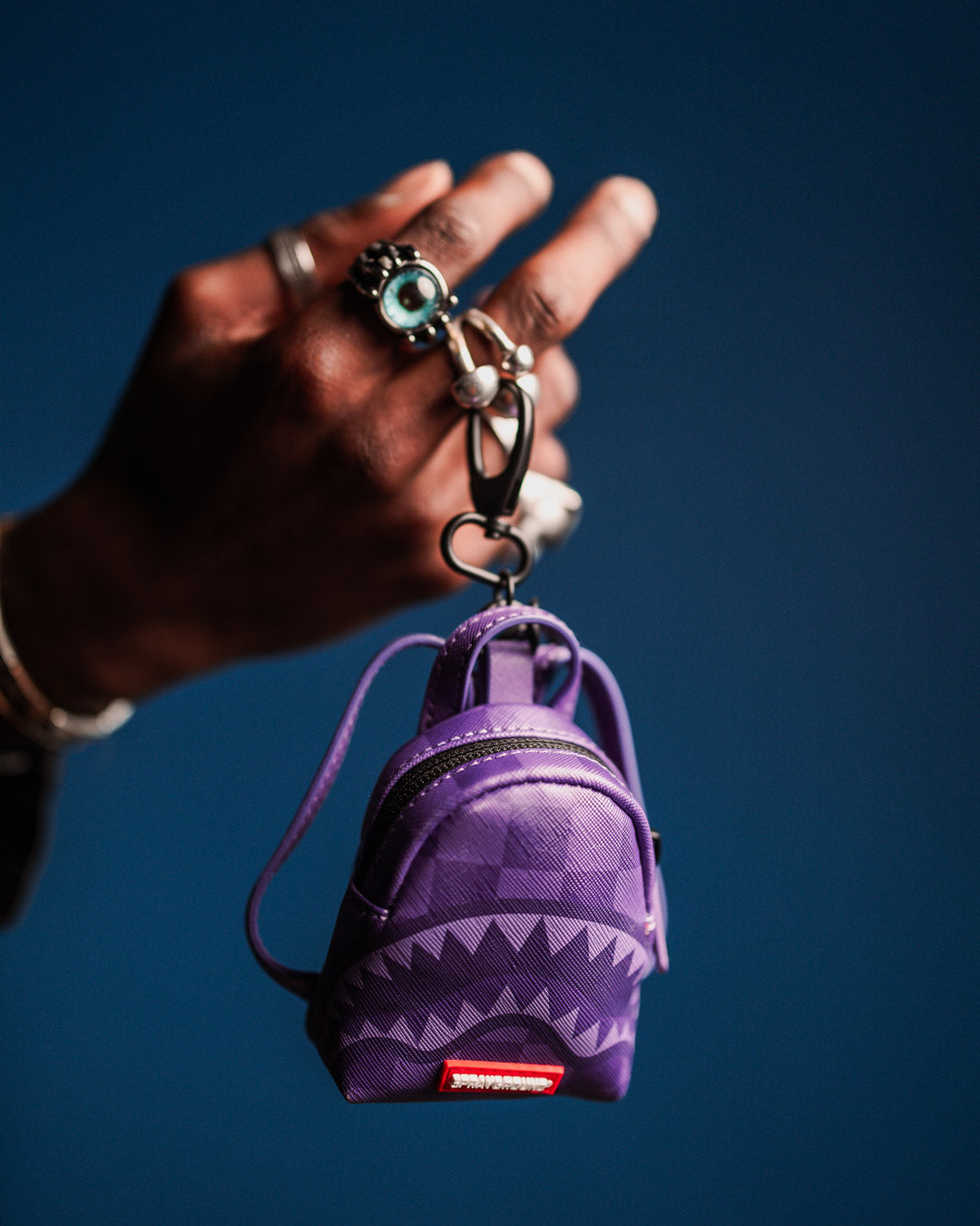 Small utility keychain holding coins and earbuds, perfect for on-the-go convenience